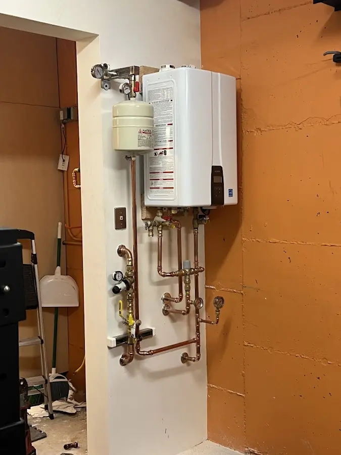 Plumbing technician inspecting water heater connections in Towson